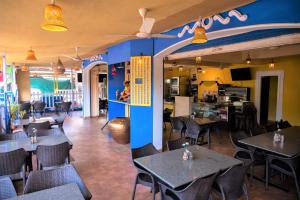 Casa Eternal Boutique Hotel - Calangute في كالانغيُت: غرفة طعام مع طاولات وكراسي في مطعم