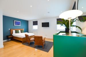 a bedroom with a bed and a table and chairs at The Warehouse at West Hampstead by Concept Apartments in London