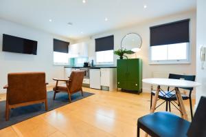 a kitchen and living room with a table and chairs at The Warehouse at West Hampstead by Concept Apartments in London
