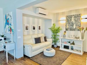uma sala de estar com um sofá branco e uma mesa em Luxury 130m2 AC, Terrace, Pool, Parking - Steps to beach, 5 min Palais des Festivals 3BR-3BA em Cannes