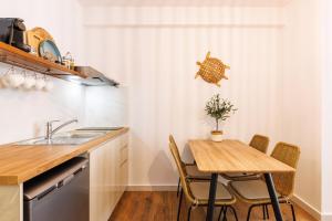 cocina con mesa, sillas y fregadero en Boho Central Suites en Tesalónica