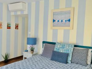 sypialnia z łóżkiem z niebieskimi i białymi paskami w obiekcie Luxury 130m2 AC, Terrace, Pool, Parking - Steps to beach, 5 min Palais des Festivals 3BR-3BA w Cannes
