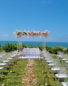 una ceremonia de boda en la playa con sillas blancas y flores en White Beach House - Kigamboni, en Kimbiji