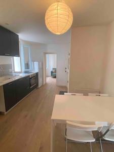 Una cocina con una mesa y sillas en una habitación. en LE GARIBALDI-Grand appartement avec 3 chambres-Gare-Wifi, en Béziers