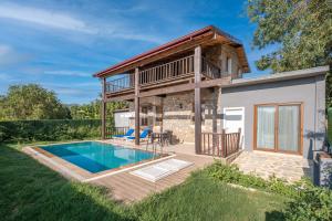 een huis met een zwembad en een terras bij Kayaköy İncir villa özel yüzme havuzlu in Fethiye