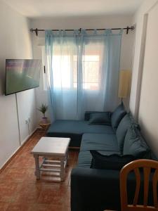 uma sala de estar com um sofá azul e uma mesa em Casa Mellis Aguamarga em Agua Amarga