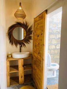 a bathroom with a sink and a mirror at Jambiani Backpackers Hostel in Jambiani