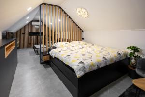 - une chambre avec un lit et une tête de lit en bois dans l'établissement Villa in the Vineyard with Pool, HotTub & Sauna, à Lendava