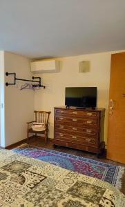 ein Schlafzimmer mit einem Flachbild-TV auf einer Kommode in der Unterkunft B&B Colorado in Bergamo