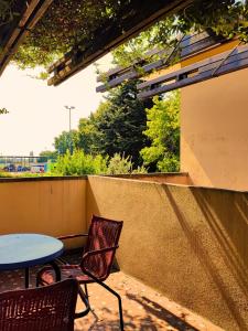 eine Terrasse mit 2 Stühlen, einem Tisch und einem Tisch in der Unterkunft B&B Colorado in Bergamo