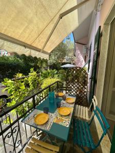 una mesa y sillas en un balcón con sombrilla en La Casa dei Fiori, en La Spezia