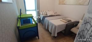 een kleine slaapkamer met een bed en een stoel bij ZARAUTZ LOFT 1 in Zarautz