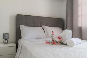 een wit bed met een bos bloemen erop bij Sweet Home Madeira in Camacha