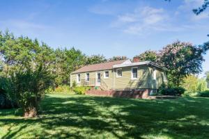 a house in a yard with a green lawn at Private 4 bed home in 1 acre lot - 10 mins to IAD airport in Herndon