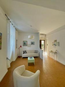 een woonkamer met een witte bank en een tafel bij La Casa dei Fiori in La Spezia