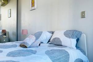 een bed met blauwe en witte lakens en kussens bij New Comfy stylish Apt in Rhodes Next to train n shopping center in Sydney
