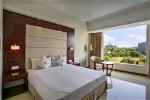 a bedroom with a large bed and a large window at Ocean Paradise Hotel and Resort in Cox's Bazar