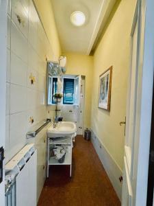 een badkamer met een wastafel en een spiegel bij La Casa dei Fiori in La Spezia