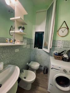 een badkamer met een wastafel, een toilet en een spiegel bij La Casa dei Fiori in La Spezia