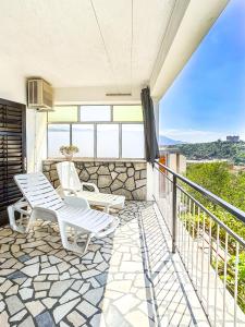 a patio with two white chairs on a balcony at Zimmer - Room - Magdalena in Senj