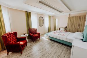 a hotel room with a bed and two chairs at Karacan Park Hotel in Dalaman