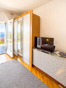 a living room with a flat screen tv and a living room with a televisionicter at Zimmer - Room - Magdalena in Senj +7 photos