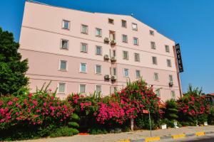 un edificio rosa con fiori rosa di fronte di Karacan Park Hotel a Dalaman