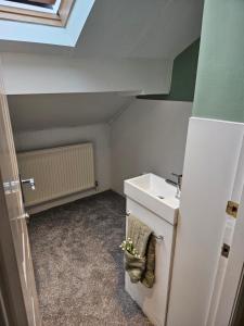 Elle comprend une petite salle de bains pourvue d'un lavabo et d'un comptoir blanc. dans l'établissement The Attic, à Dove Holes