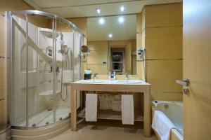 y baño con ducha, lavabo y bañera. en Hotel Nelva en Murcia