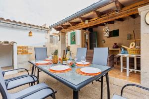 einen Tisch und Stühle in einem Zimmer mit Küche in der Unterkunft Casa Sergi mit kleinem Pool und Wifi in Cala Llombards
