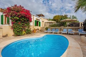 eine Villa mit einem Pool und Blumen in der Unterkunft Casa Sergi mit kleinem Pool und Wifi in Cala Llombards