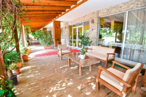 un patio con sillas, una mesa y algunas plantas en Karacan Park Hotel - Dalaman Airport, en Dalaman