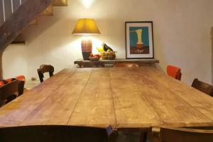 a large wooden table in a room with chairs at Chalet 1900, gîte de caractère in Nescus