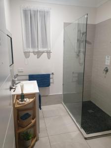 a bathroom with a shower and a sink at GUESTHOUSE on REGENT Bed & Breakfast in Caloundra