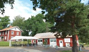 a red barn and a building with a tree at Sparreholm Bed and Breakfast in Sparreholm +18 photos