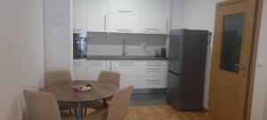 a small kitchen with a table and a refrigerator at Ivan in Livno