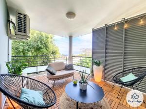 d'un balcon avec des chaises, un canapé et une table. dans l'établissement T3 - Tropical Lodge - 3 étoiles - 65m2 - Saint-Pierre, à Saint-Pierre