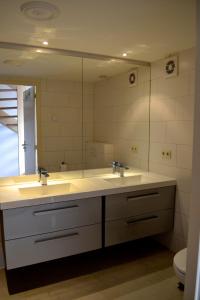 baño con 2 lavabos y espejo grande en De Moolt Vakantiewoningen, en Eckelrade