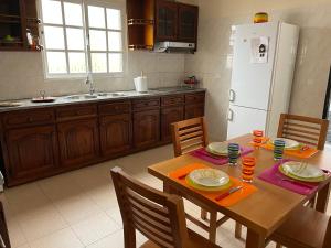 una cucina con tavolo in legno e frigorifero bianco di Vivenda da Praia a Machico