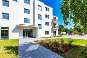 a white building with a walkway in front of it at D.W.Sunset in Jastrzębia Góra