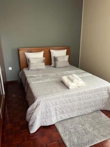 1 cama con 2 almohadas y 2 toallas. en Vivenda da Praia, en Machico
