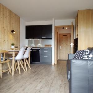 uma cozinha e sala de estar com mesa e cadeiras em Gentianes COSY & MOUNTAIN apartments em Veysonnaz