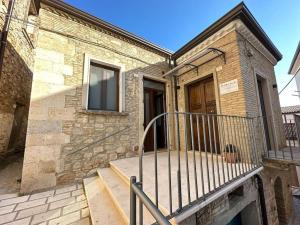 Cette maison en briques dispose d'un balcon et d'une porte. dans l'établissement Casa Nazzaro, à Deliceto