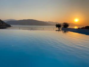 a swimming pool with the sunset in the background at Z-Villas Beach Hotel in Marmaris