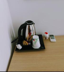 a tea kettle on a table next to a remote control at Hotel Esperanza in Florence