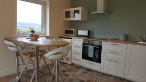 uma cozinha com uma mesa de madeira e uma mesa com cadeiras em Apartment with Private Pool Sleeps 5 em Mitchelstown