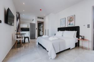 een slaapkamer met een groot wit bed en een tafel bij Pearl Apartel in Volos