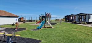 a park with a playground with a slide at Ashdale By Sea in Whitstable