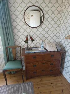 a room with a dresser and a mirror and a chair at Sparreholm Bed and Breakfast in Sparreholm