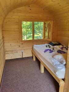 um quarto com uma cama num chalé de madeira em Cristel Căsuța Fără Gânduri em Mesentea